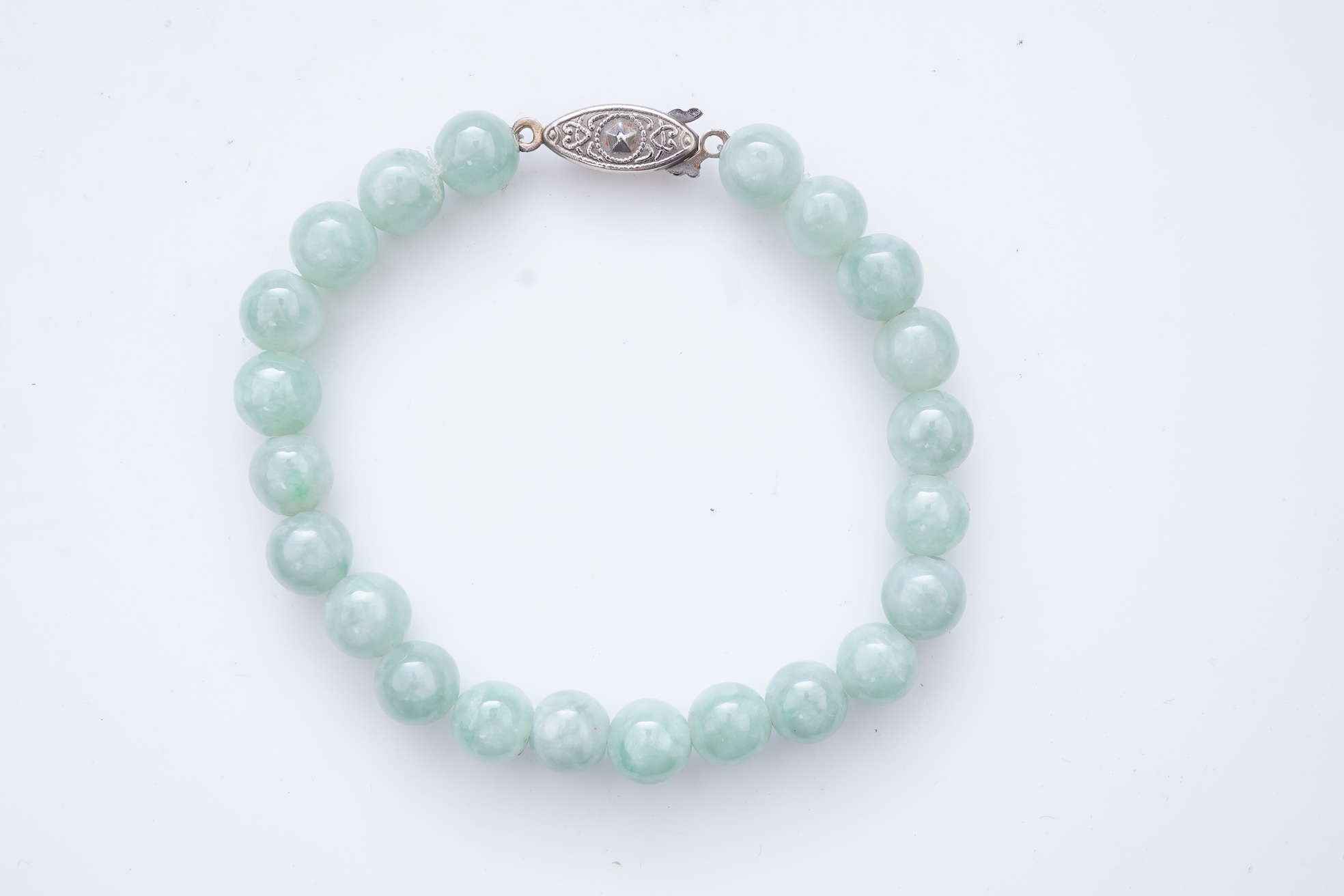A collection of jadeite jewels, comprising: a bead bracelet with a silver clasp; together with three pairs of studs; one pair of hoop studs, one broken and restuck; and one pair of drop earrings, each set with jadeite, m